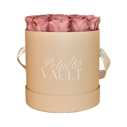 Beige cylindrical hat. box with dusty pink roses and 'Petal & Vault' branding on a white background