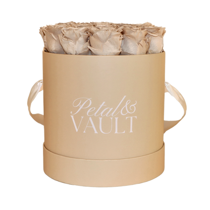 Beige cylindrical hat box with 'Petal & Vault' branding containing beige roses on a white background