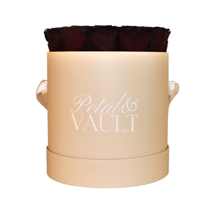 Beige cylindrical hat box container with a dark red rose on a white background, branded 'Petal & Vault'.